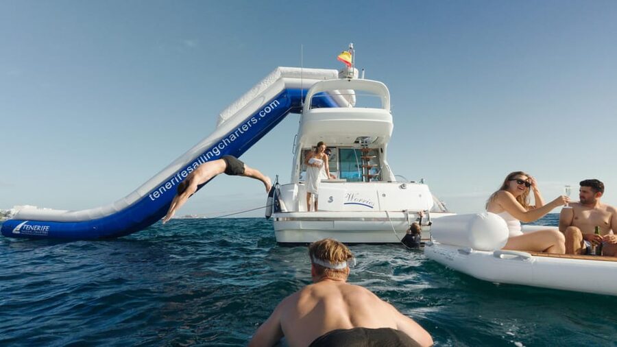 Tenerife: 6 & 8 Hour Private Luxury Motorboat Charter - The boat day experience: slide, music, safety gear, and a crew doing the heavy lifting